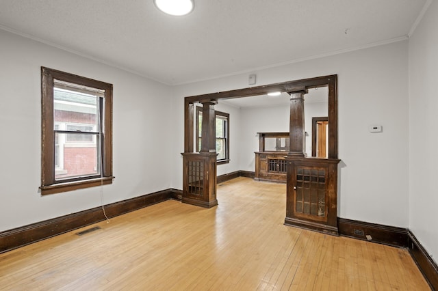 3400 Elliot Ave S, Minneapolis, MN 55407 - spare room with decorative columns, light wood-style floors, crown molding, and baseboards