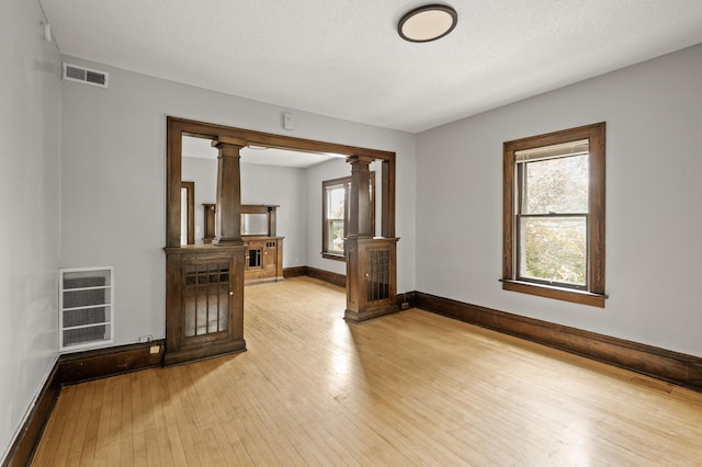3400 Elliot Ave S, Minneapolis, MN 55407 - spare room featuring ornate columns, light wood-style floors, and baseboards