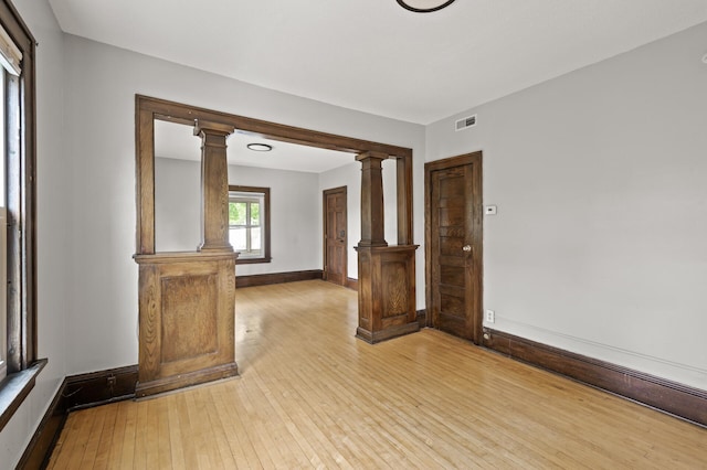 3400 Elliot Ave S, Minneapolis, MN 55407 - spare room with ornate columns, light wood-style floors, and baseboards