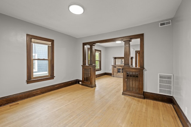 3400 Elliot Ave S, Minneapolis, MN 55407 - unfurnished room featuring decorative columns, light wood finished floors, and baseboards