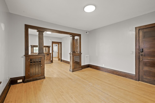 3400 Elliot Ave S, Minneapolis, MN 55407 - empty room with ornate columns, light wood-style flooring, and baseboards