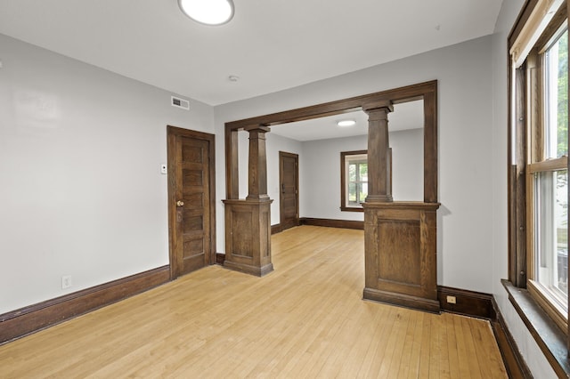 3400 Elliot Ave S, Minneapolis, MN 55407 - unfurnished room featuring ornate columns, light wood-type flooring, and baseboards