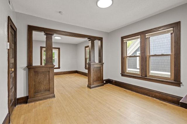 3400 Elliot Ave S, Minneapolis, MN 55407 - empty room featuring decorative columns, light wood-type flooring, and baseboards