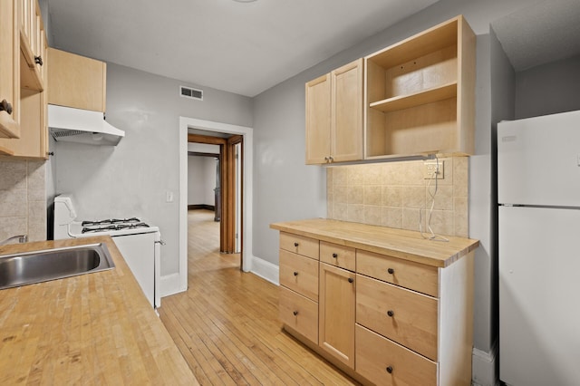 3400 Elliot Ave S, Minneapolis, MN 55407 - kitchen featuring white appliances, under cabinet range hood, butcher block counters, light brown cabinetry, and tasteful backsplash