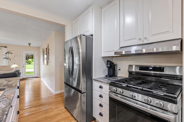 72 7th St, Cochrane, WI 54622 - kitchen featuring appliances with stainless steel finishes, under cabinet range hood, light wood-style flooring, white cabinets, and open floor plan