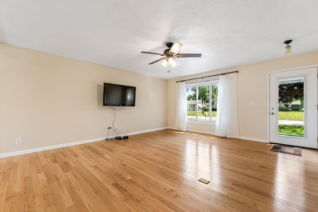 72 7th St, Cochrane, WI 54622 - unfurnished living room with light wood-type flooring, a ceiling fan, and a textured ceiling