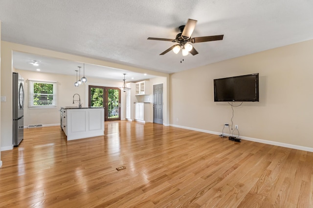 72 7th St, Cochrane, WI 54622 - unfurnished living room featuring ceiling fan, light wood finished floors, and a textured ceiling