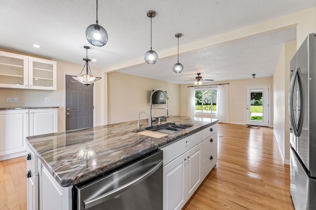 72 7th St, Cochrane, WI 54622 - kitchen featuring stainless steel appliances, a center island with sink, a textured ceiling, white cabinetry, and light wood-type flooring