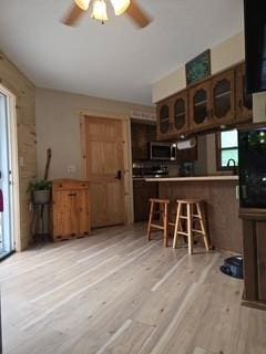 19146 Eaglewood Rd, Lynden Twp, MN 55320 - kitchen featuring healthy amount of natural light, stainless steel microwave, light wood-style flooring, and glass insert cabinets