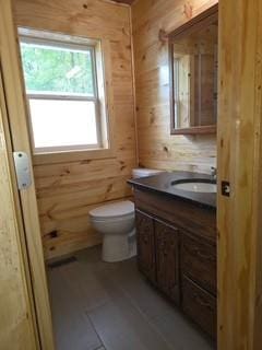 19146 Eaglewood Rd, Lynden Twp, MN 55320 - bathroom featuring vanity, toilet, and wooden walls