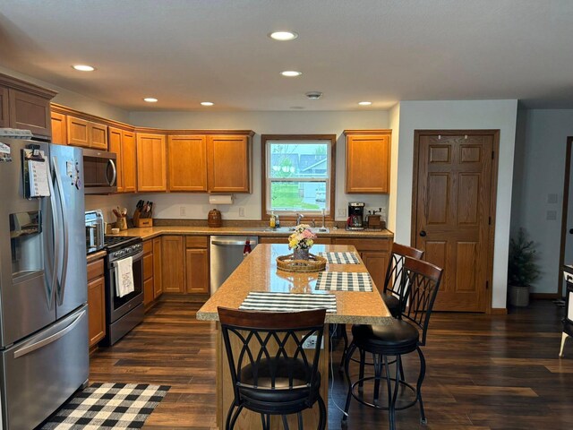1108 11th Ave SE, Waseca, MN 56093 - kitchen featuring stainless steel appliances, dark wood-style flooring, recessed lighting, a sink, and a breakfast bar area
