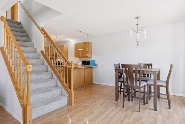 5995 Wedgewood Ln N Unit 84, Plymouth, MN 55446 - dining room with light wood-type flooring, stairs, baseboards, and a chandelier
