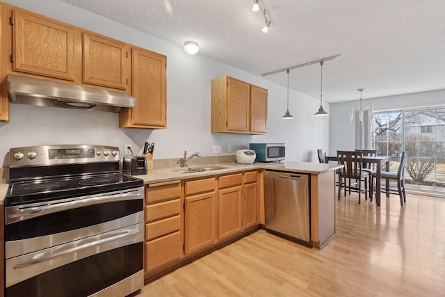 5995 Wedgewood Ln N Unit 84, Plymouth, MN 55446 - kitchen featuring stainless steel appliances, under cabinet range hood, a sink, light wood-style floors, and light countertops