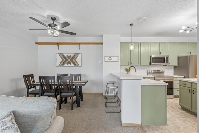 803 Willow Glen Ct, Buffalo, MN 55313 - kitchen featuring green cabinetry, stainless steel appliances, light countertops, a textured ceiling, and a peninsula