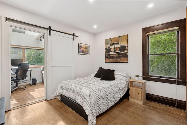 1104 21st Ave SE, Minneapolis, MN 55414 - bedroom featuring wood-type flooring, multiple windows, a barn door, a desk, and recessed lighting