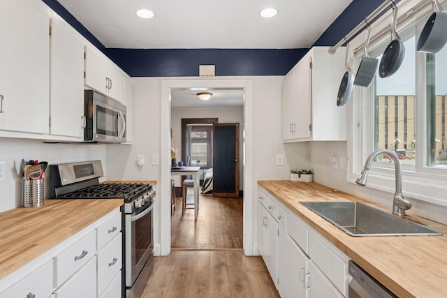 1104 21st Ave SE, Minneapolis, MN 55414 - kitchen featuring stainless steel appliances, healthy amount of natural light, white cabinets, and recessed lighting