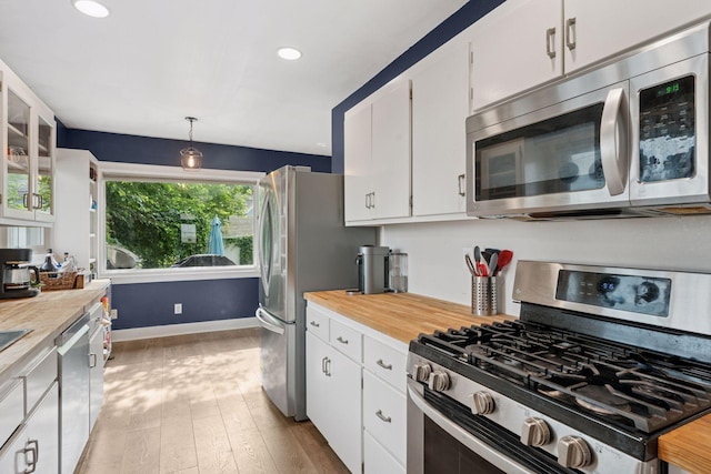 1104 21st Ave SE, Minneapolis, MN 55414 - kitchen featuring appliances with stainless steel finishes, light wood finished floors, white cabinetry, recessed lighting, and hanging light fixtures