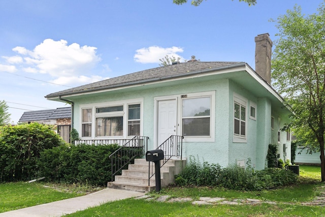 1104 21st Ave SE, Minneapolis, MN 55414 - bungalow with stucco siding, a chimney, and a front yard