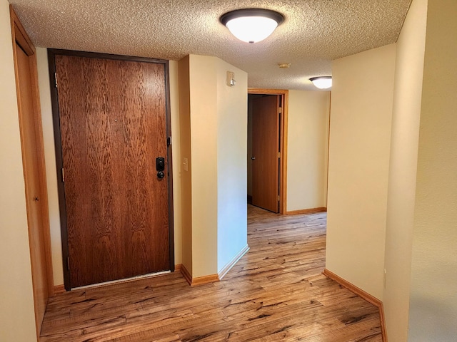 520 5th St SW Unit 318, Willmar, MN 56201 - hallway with wood finished floors, a textured ceiling, and baseboards