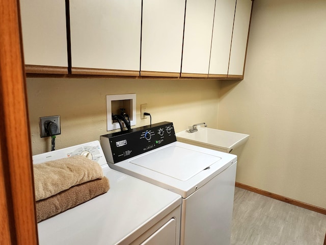 520 5th St SW Unit 318, Willmar, MN 56201 - laundry area with washing machine and clothes dryer, cabinet space, light wood finished floors, and baseboards