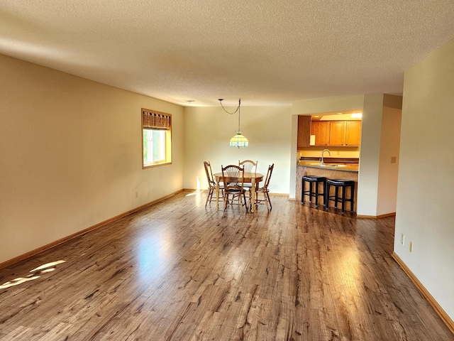 520 5th St SW Unit 318, Willmar, MN 56201 - dining area with wood finished floors, a textured ceiling, and baseboards