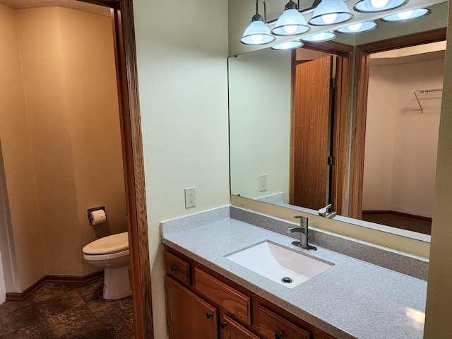 520 5th St SW Unit 318, Willmar, MN 56201 - bathroom with vanity, toilet, stone finish floors, and baseboards