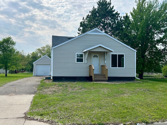 609 4th St NW, Wadena, MN 56482 - bungalow-style home with driveway, an outdoor structure, a front yard, and a detached garage