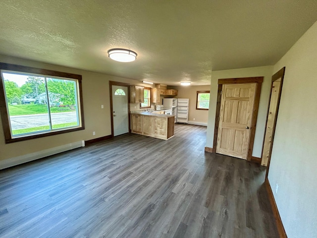 609 4th St NW, Wadena, MN 56482 - unfurnished living room featuring baseboards, dark wood-style floors, a baseboard radiator, and a textured ceiling