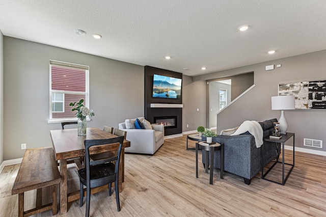 12719 Erskin St NE, Blaine, MN 55449 - living area featuring a large fireplace, a textured ceiling, light wood finished floors, recessed lighting, and baseboards