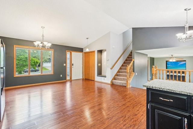 1504 Monarch St, Shakopee, MN 55379 - kitchen with a chandelier, dark cabinetry, wood finished floors, a ceiling fan, and high vaulted ceiling