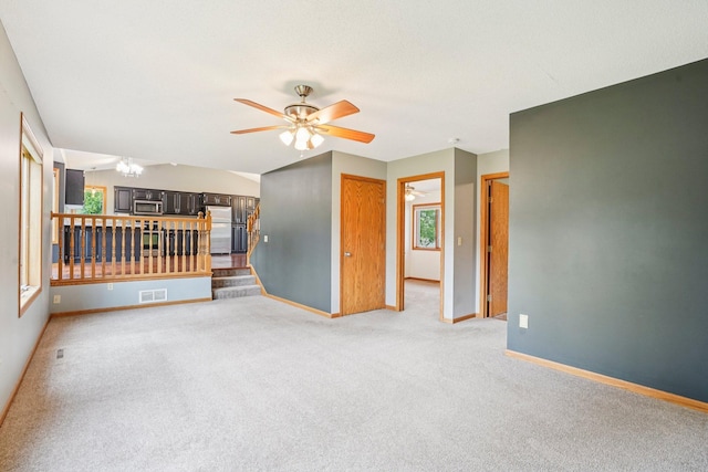 1504 Monarch St, Shakopee, MN 55379 - unfurnished living room featuring ceiling fan, light colored carpet, and stairs