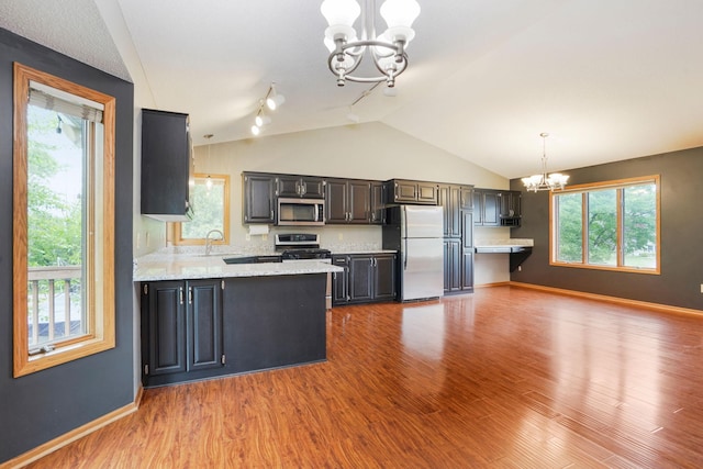 1504 Monarch St, Shakopee, MN 55379 - kitchen with freestanding refrigerator, a chandelier, stainless steel microwave, track lighting, and lofted ceiling