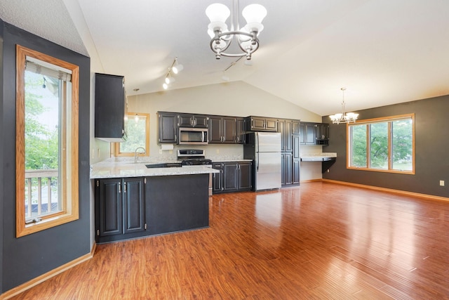 1504 Monarch St, Shakopee, MN 55379 - kitchen featuring freestanding refrigerator, a chandelier, stainless steel microwave, vaulted ceiling, and wood finished floors