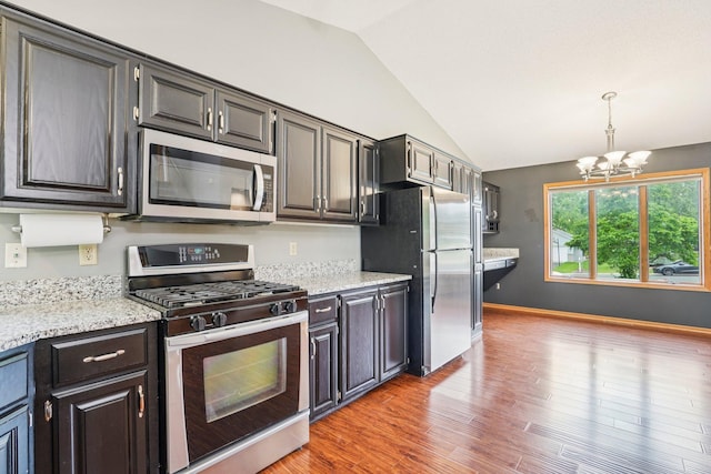 1504 Monarch St, Shakopee, MN 55379 - kitchen with appliances with stainless steel finishes, lofted ceiling, a chandelier, light wood-style flooring, and pendant lighting