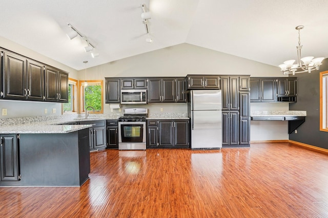 1504 Monarch St, Shakopee, MN 55379 - kitchen with appliances with stainless steel finishes, rail lighting, a chandelier, decorative light fixtures, and high vaulted ceiling