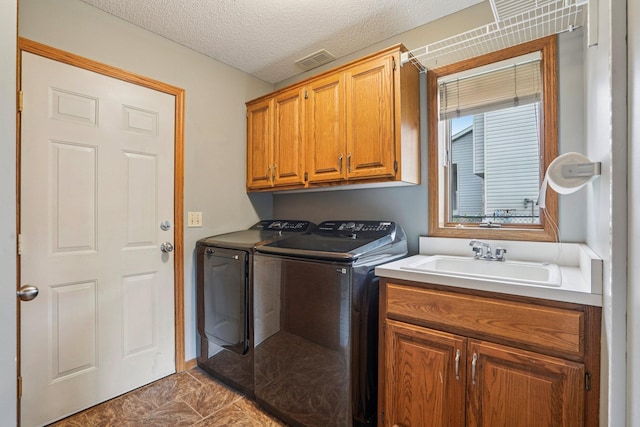 1504 Monarch St, Shakopee, MN 55379 - laundry room featuring washer and dryer, cabinet space, a textured ceiling, and marble look tiles