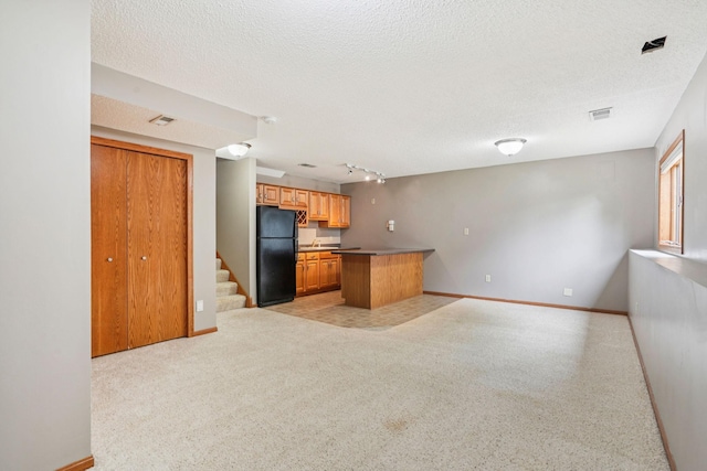1504 Monarch St, Shakopee, MN 55379 - kitchen with freestanding refrigerator, open floor plan, a textured ceiling, and rail lighting
