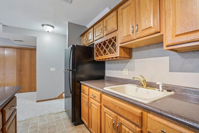 1504 Monarch St, Shakopee, MN 55379 - kitchen with dark countertops, light carpet, a textured ceiling, brown cabinetry, and freestanding refrigerator