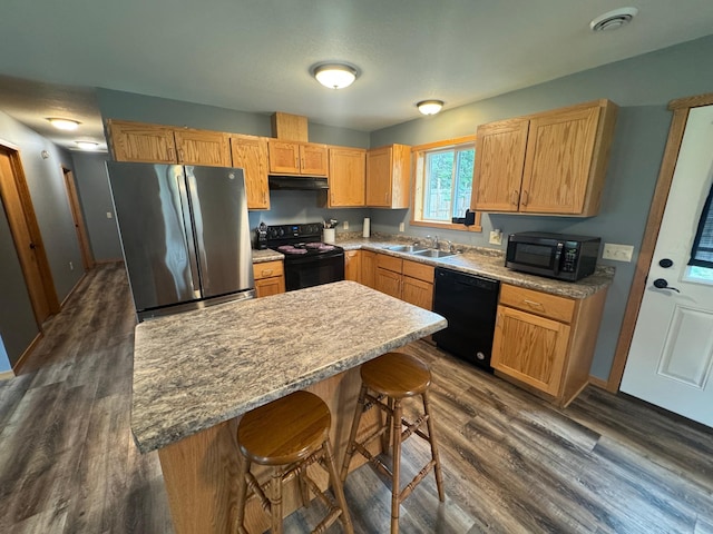 1101 Timbers Dr, Park Rapids, MN 56470 - kitchen featuring black appliances, a sink, a breakfast bar, dark wood-style floors, and a center island