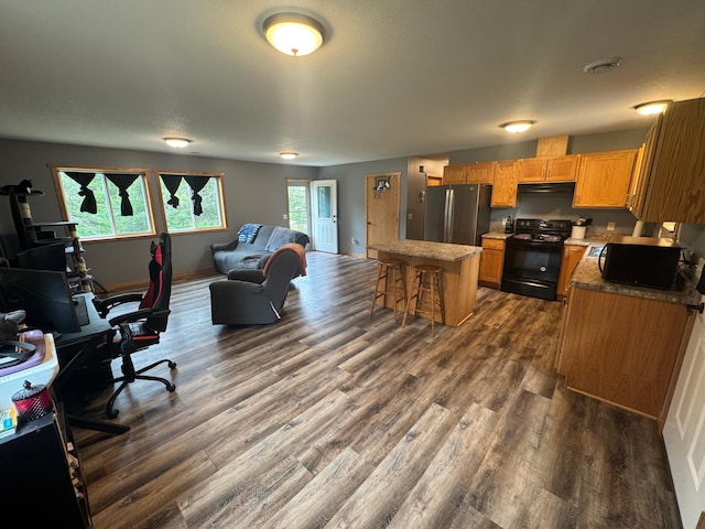 1101 Timbers Dr, Park Rapids, MN 56470 - kitchen with black appliances, dark wood-style floors, a kitchen island, a kitchen bar, and open floor plan