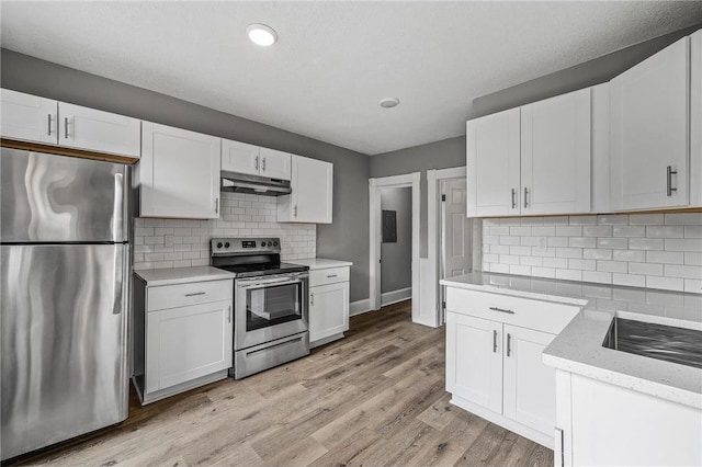 608 Beaumont St, Saint Paul, MN 55130 - kitchen with stainless steel appliances, under cabinet range hood, white cabinets, light wood finished floors, and recessed lighting