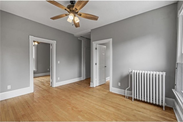 608 Beaumont St, Saint Paul, MN 55130 - spare room with radiator heating unit, a ceiling fan, light wood finished floors, and baseboards