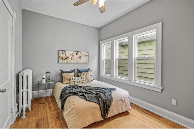 608 Beaumont St, Saint Paul, MN 55130 - bedroom featuring radiator, hardwood / wood-style floors, baseboards, and a ceiling fan