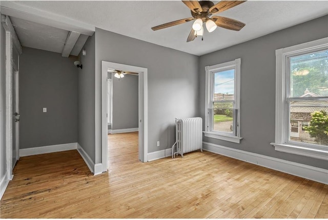 608 Beaumont St, Saint Paul, MN 55130 - empty room with radiator, light wood finished floors, baseboards, and a ceiling fan