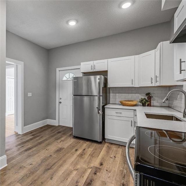 608 Beaumont St, Saint Paul, MN 55130 - kitchen with freestanding refrigerator, electric range oven, a sink, light countertops, and tasteful backsplash