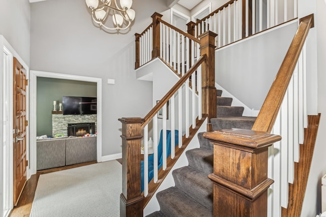 3720 Ximines Ln N, Plymouth, MN 55441 - stairway with a high ceiling, a chandelier, wood finished floors, and a stone fireplace