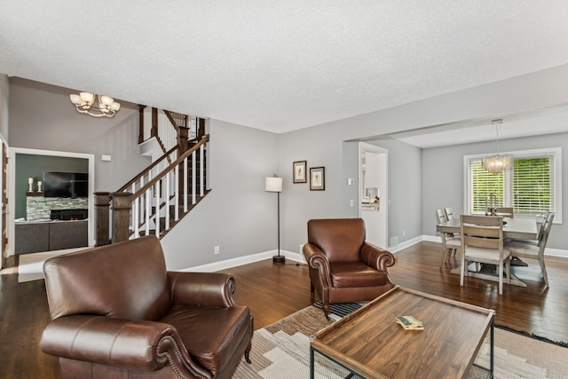 3720 Ximines Ln N, Plymouth, MN 55441 - living room with wood finished floors, a chandelier, stairs, a textured ceiling, and a stone fireplace