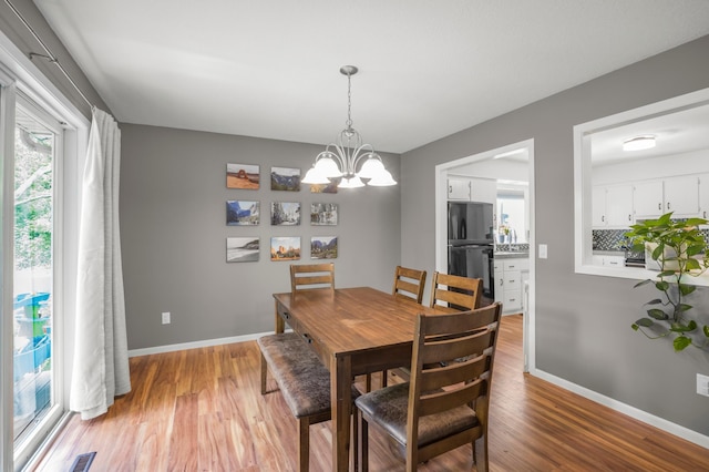 324 Meadow Run Dr SW, Rochester, MN 55902 - dining room with a chandelier, light wood-style flooring, and baseboards
