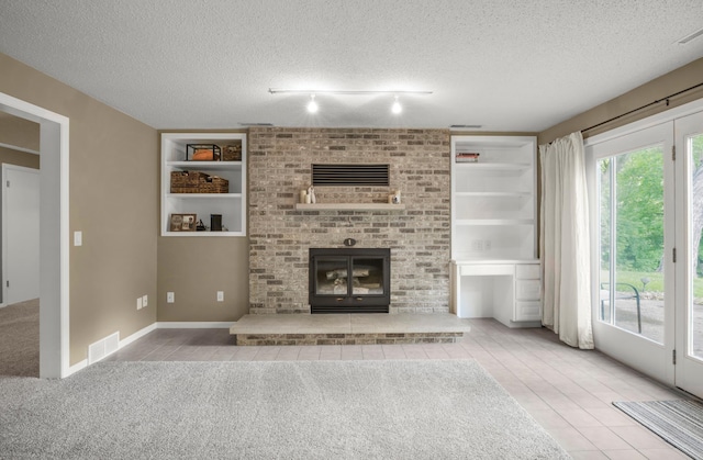 324 Meadow Run Dr SW, Rochester, MN 55902 - unfurnished living room featuring a textured ceiling, built in features, tile patterned flooring, a brick fireplace, and carpet