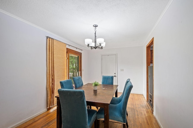 2065 124th Ln NW, Coon Rapids, MN 55448 - dining space with a chandelier, ornamental molding, a textured ceiling, wood finished floors, and baseboards